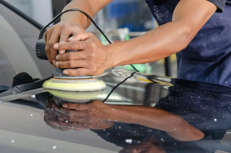Dual-action polisher with a yellow pad working dark paint