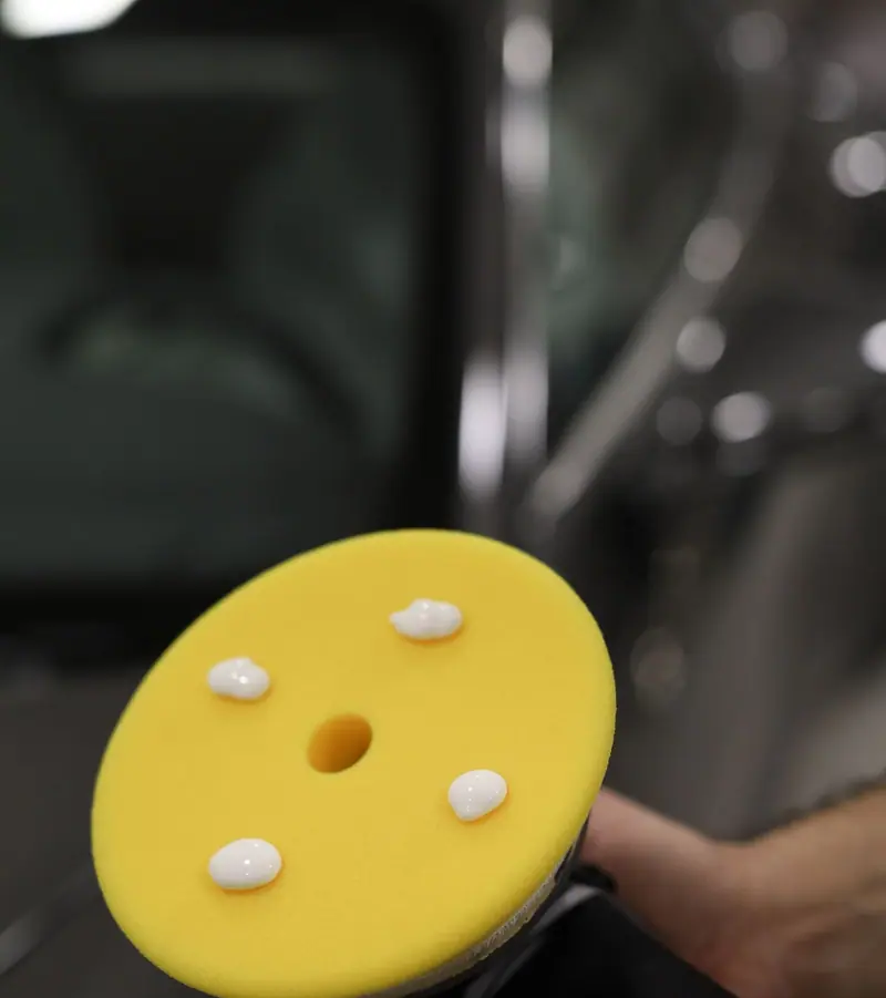 Yellow foam polishing pad with compound, close up