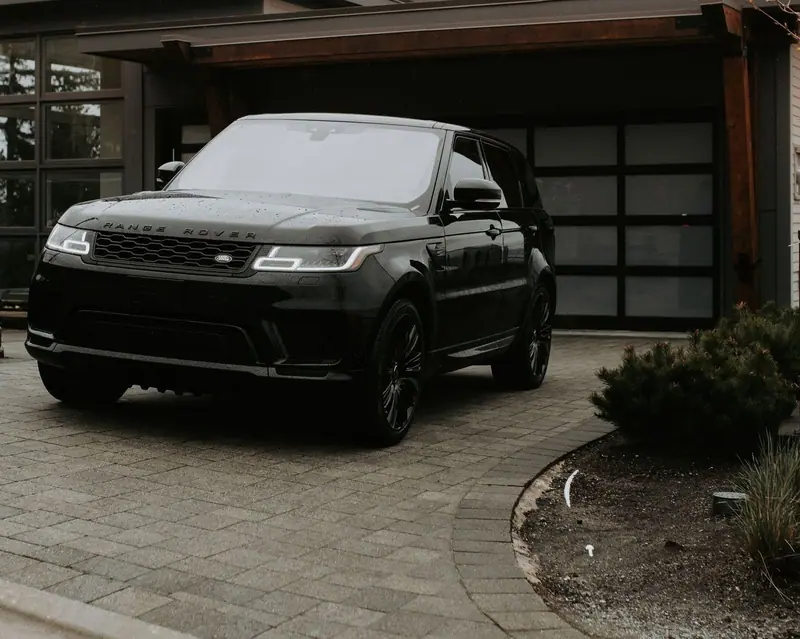 Black SUV gleaming on a paver driveway after a full detail