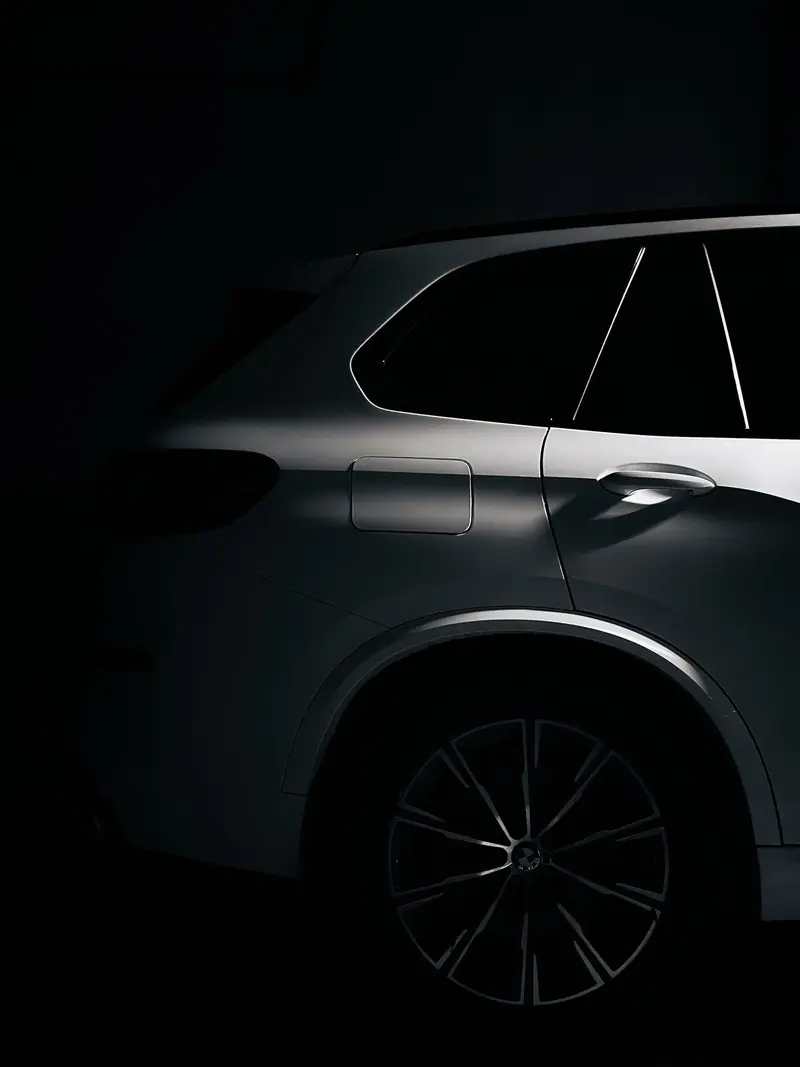 Dark SUV side panel catching raking light on clean paint