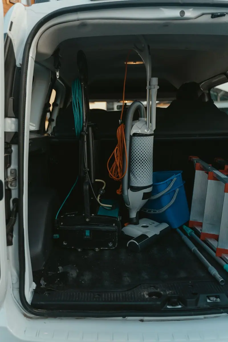 Work van with rear doors open, vacuum and bucket inside