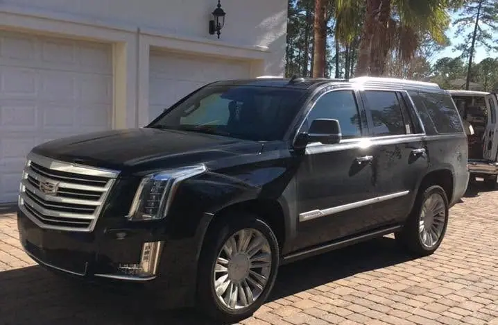 Black Cadillac Escalade parked on a brick paver driveway after a detail