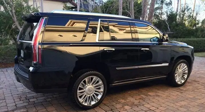 Rear quarter of a black Cadillac Escalade showing a mirror reflection after a detail