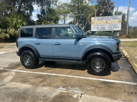 Light blue Ford Bronco detailed in a St. Augustine parking lot by the Limelight Theatre sign