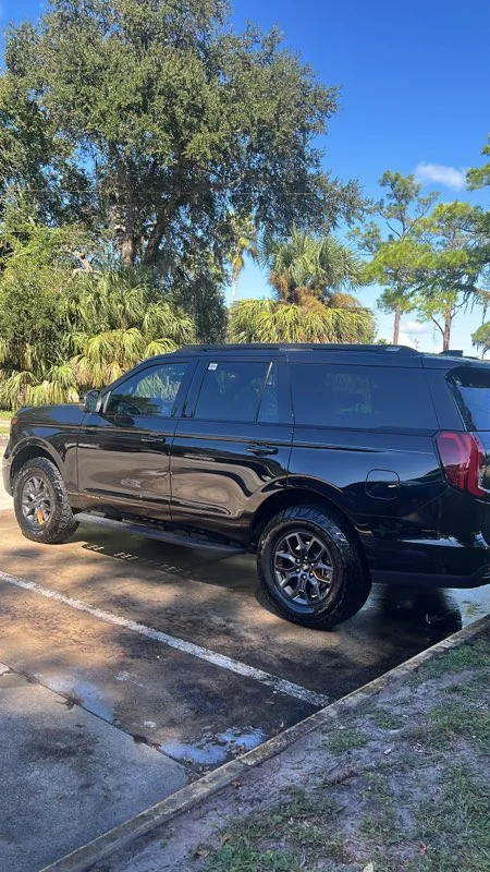 Black full-size SUV with a deep gloss after a detail